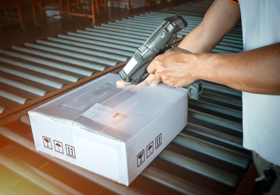 Operator produkcji skanujący kod partii przy stanowisku roboczym w zakładzie produkcyjnym.